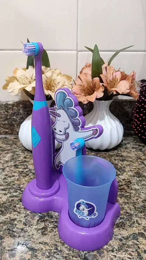 Kit roxo sobre a bancada do banheiro, com escova, base e copo